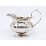 A William IV silver gadroon bodied handled milk/cream jug, with initialled front and gilt