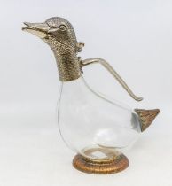 A novelty glass and plate mounted claret jug in the form of a duck, with a glass body. (wearing to