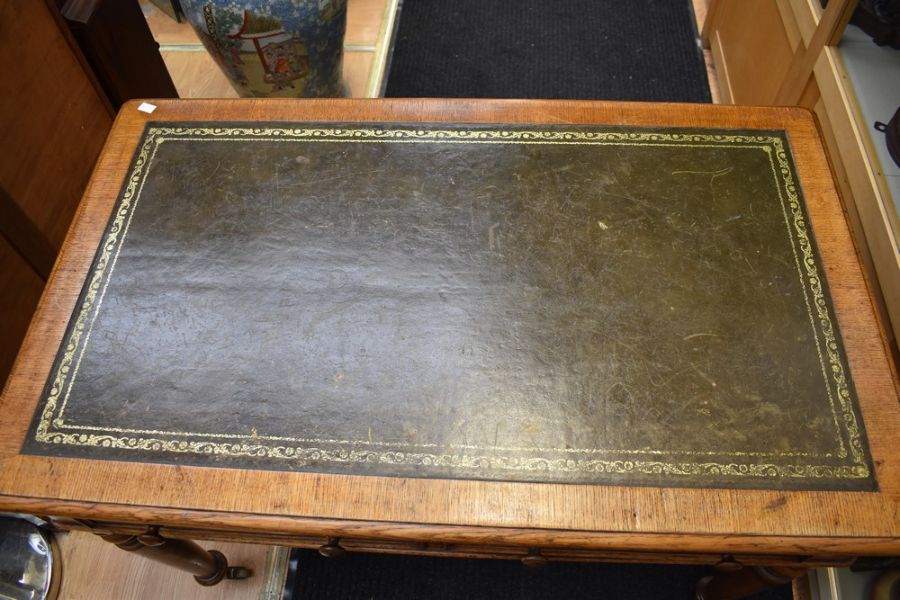 An early 20th century light oak olive green tooled leather topped office desk with four turned - Image 2 of 3