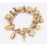 A 9ct charm bracelet suspending various novelty charms including champagne bucket, elephant, ten