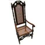 A Charles II oak armchair, carved top back rest, turned supports with finials, cane back and seat,