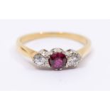 A diamond and ruby three stone 18ct gold, comprising a central round cut ruby, approx 4mm, with
