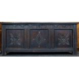 A mid-to-late 17th Century oak coffer, three front carved panels, carved top rail, plain three-