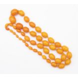 A resin/plastic and amber composite bead necklace, comprising oval graduated beads the ;largest