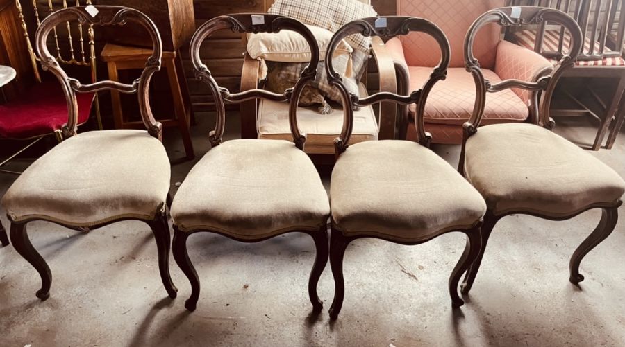 A set of four early Victorian walnut carved chairs, scrolling spoon back, serpentine stuffed seat,