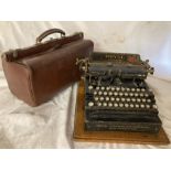 Gladstone Doctors bag brown Leather, metal bar fastening to top. Royal Type writer on wooden base,