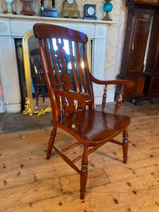 A 20th century elm and beech stained farmhouse armchair, pierced splat and spindle back, scrolling