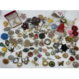 A large collection of 83 different brooches, two scarf clips, a small bag of charity pins and a