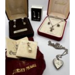 A selection of silver jewellery comprising a pendant and earring set with garnets, a silver heart