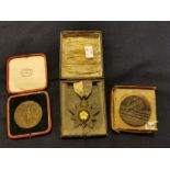 Two medallion coins to include a sinking the Lusitania and, a medal in a red leather case.