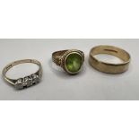 A group of three 9ct gold rings comprising a three stone diamond ring, each measuring