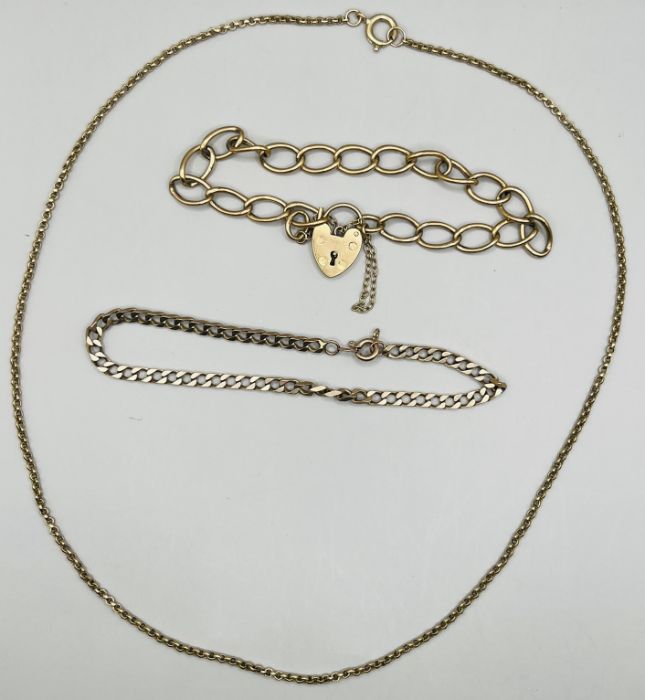 A selection of 9ct gold jewellery comprising a heart padlock clasoed charm bracelet; a curb chain