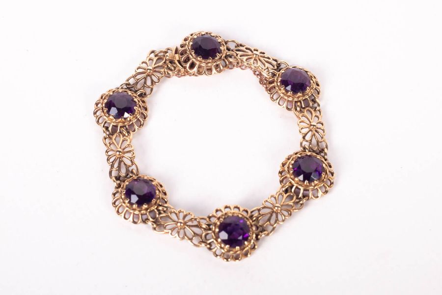 An Amethyst bracelet set with six very fine deep coloured Amethysts in yellow metal in a floral