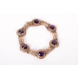 An Amethyst bracelet set with six very fine deep coloured Amethysts in yellow metal in a floral
