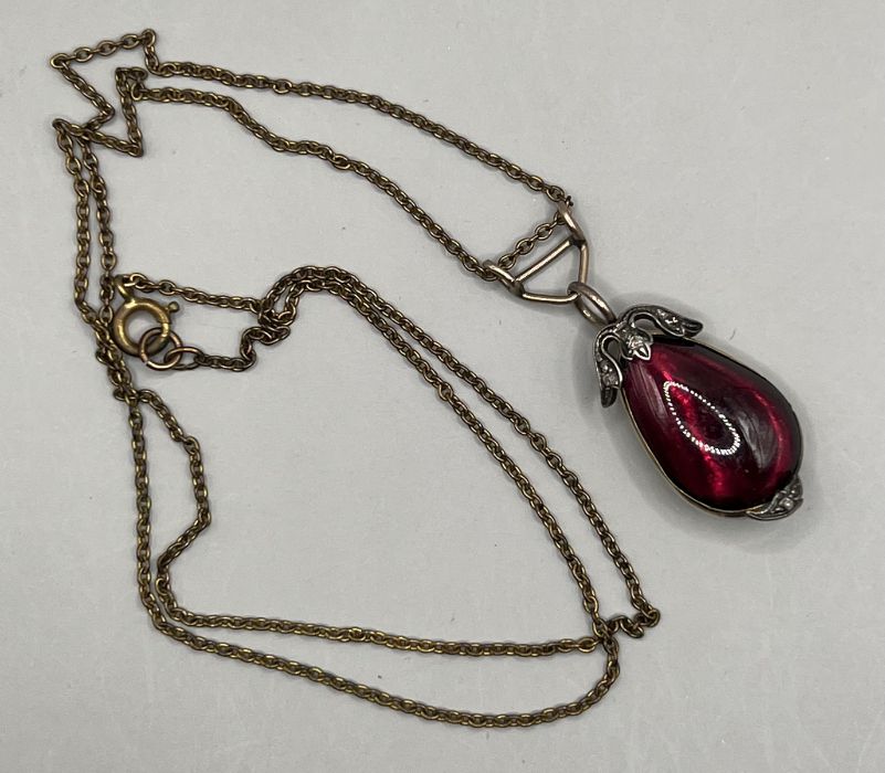 A diamond and garnet pendant in closed back yellow and white metal (please note denting to