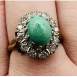 An 18ct gold turquoise and diamond cluster ring. Featuring a pale blueish green turquoise sugar loaf