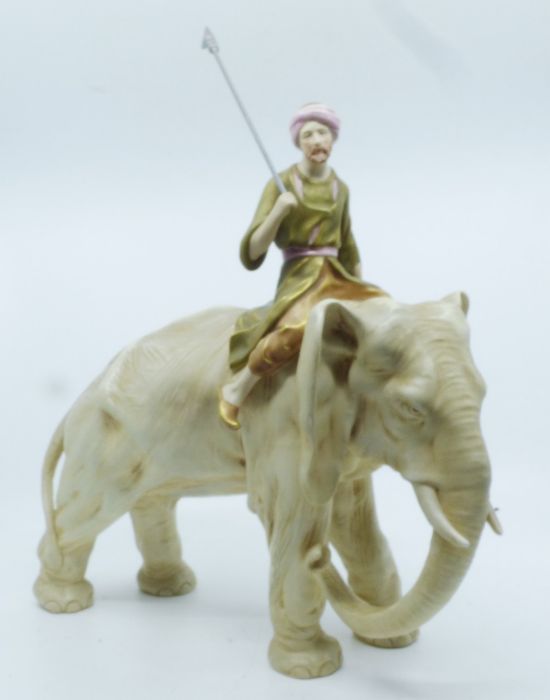A Royal Dux model of an elephant and Mahout, the Mahout dressed in robes and carrying a lance,