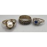 Three 9ct gold dress rings: A cultured pearl dress ring, size Q; A blue and white paste full