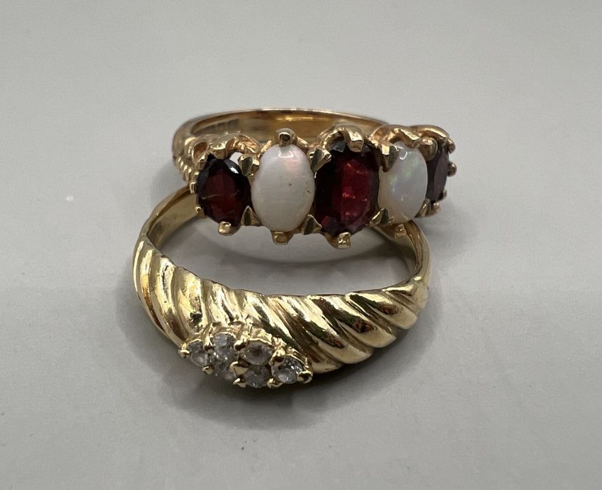 Two dress rings: An opal and garnet set 9ct gold half hoop ring, approximate gross weight 4.3 grams,