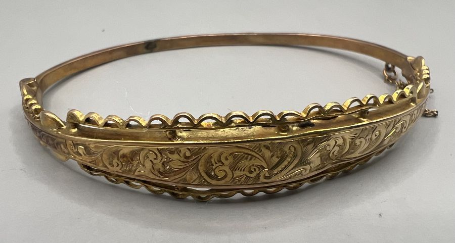 A 9ct gold hinged hollow bangle with wire and engraving decoration. Hallmarked Birmingham 1915. As