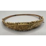 A 9ct gold hinged hollow bangle with wire and engraving decoration. Hallmarked Birmingham 1915. As