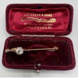 Yellow metal bar brooch set with and off centre Old European cut diamond, in a raised claw