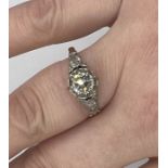 A diamond solitaire ring, in an early 20th century raised setting, in yellow and white metal . The