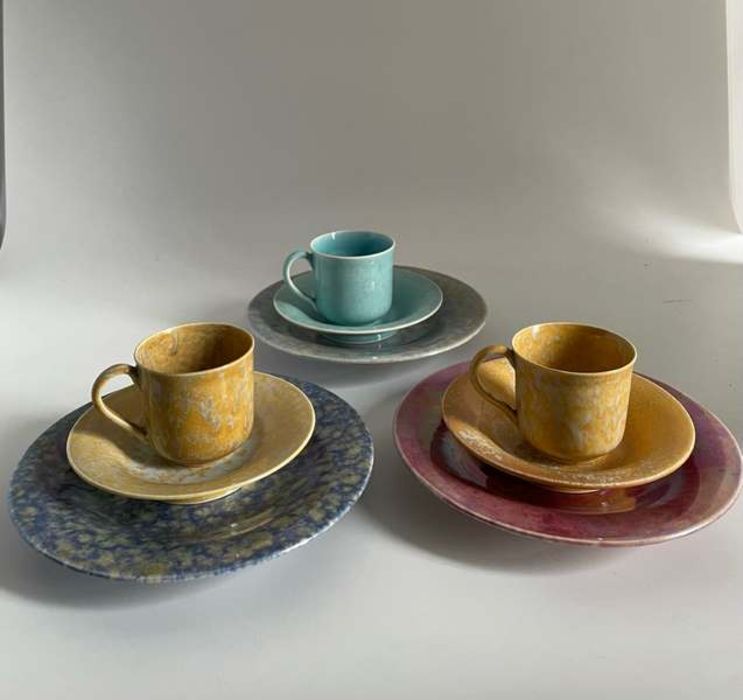 Three Ruskin Pottery lustre coffee cups and saucers, two yellow one blue. Marked Ruskin England