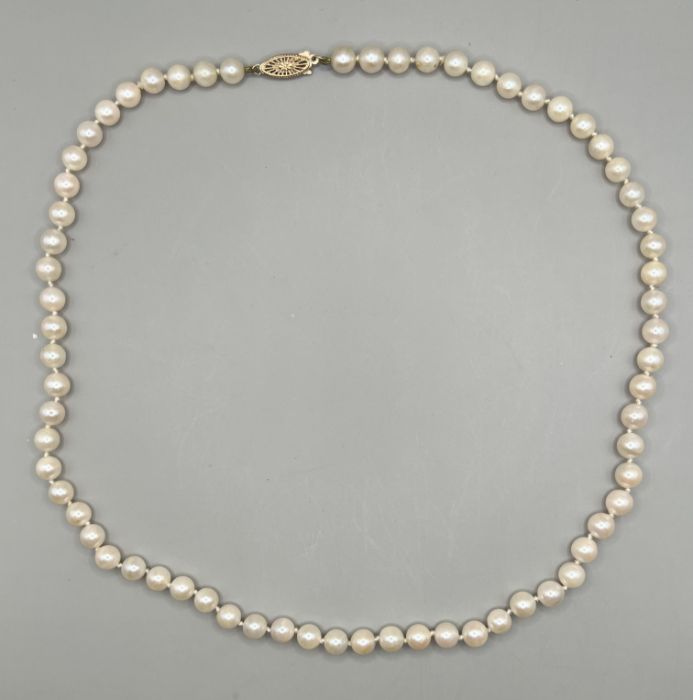 A strand of cream coloured pearls with a greenish pink orient with a 375 stamped clasp.