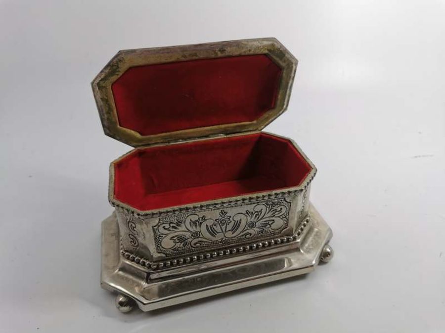 A white metal canted rectangular cigarette box with foliate scrolling design, ball feet, Arabic - Image 2 of 3