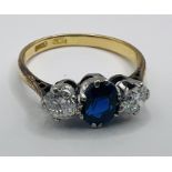 A sapphire and diamond trilogy ring. Stamped 18ct. Diamonds are round brilliant cut and of an