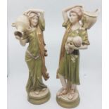 A pair of Royal Dux figures of a male fruit collector and a female water carrier, painted in typical