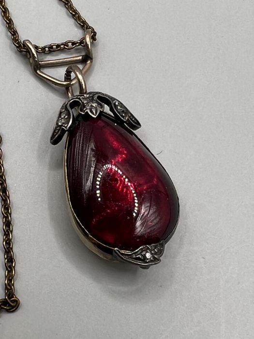 A diamond and garnet pendant in closed back yellow and white metal (please note denting to - Image 2 of 3