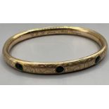 A Victorian green paste set hinged filled gold bangle. Marked F&B PAT - marks for Foster & Bailey,