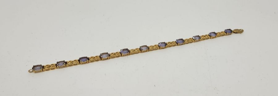 A 9ct. gold and tanzanite set bracelet, having eleven mixed oval cut tanzanites set links