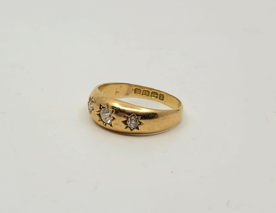 An 18ct. gold three stone diamond ring, Birmingham 1924, gypsy set three graduated old-cut diamonds,