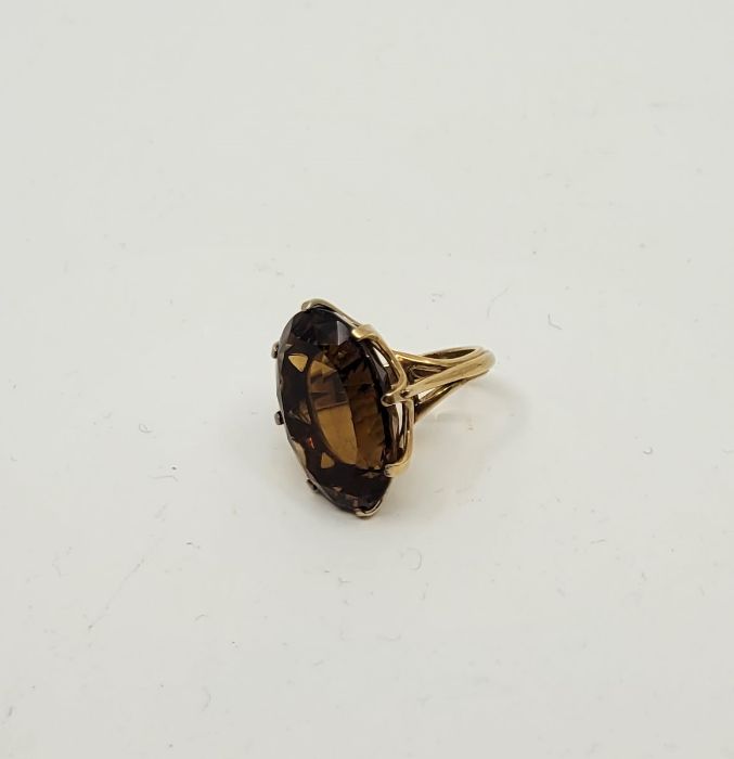 A 9ct. gold and citrine cocktail ring, London 1981, claw set large mixed cut citrine, approx. size