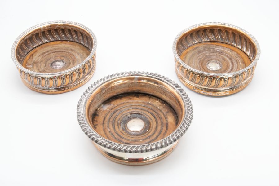 A pair of 19th Century silver plated wine coaster, gadroon borders, turned wooden bases, stamped