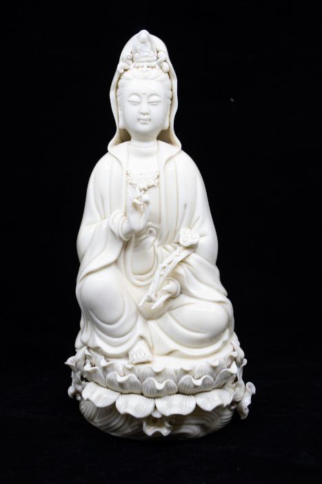 A Chinese Dehua figure of Guanyin, late Qing Dynasty/ early Republic, seated on a lotus dais