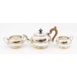 A George V silver three piece tea service comprising teapot, sugar bowl and milk jug, plain circular