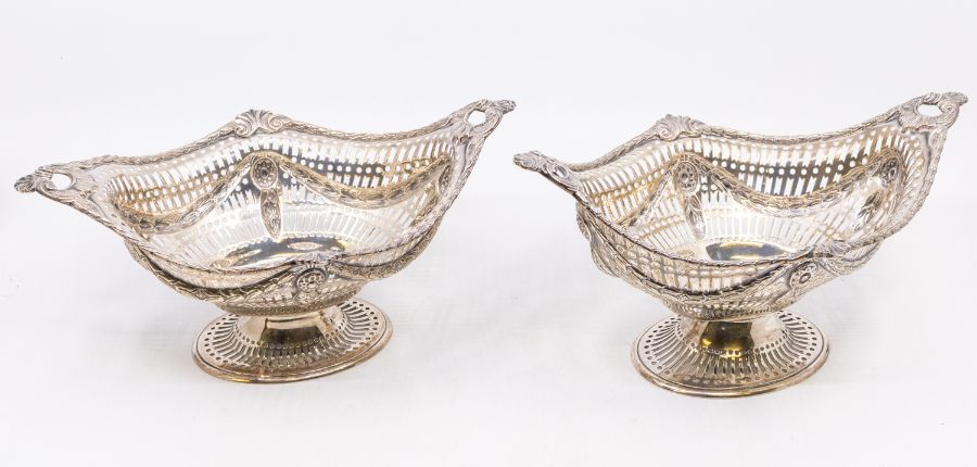 A matched pair of silver Victorian Neo-Classical baskets, border cast with anthemion and bell