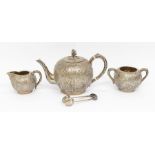 An early 20th Century Chinese Export silver three piece tea service and matching sugar tongs,