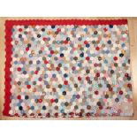 A large Victorian patchwork quilt, fine example with hexagonal panels within cherry red wavy border,