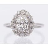 A diamond and platinum cluster ring comprising a pear shaped old cut diamond to the centre