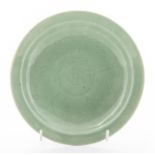 A late Ming celadon small circular dish, with combed mallow leaf central decoration, four