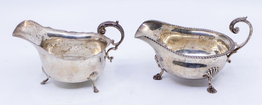 Two George V silver sauceboats, one with gadroon border on three shell and hoof feet, hallmarked