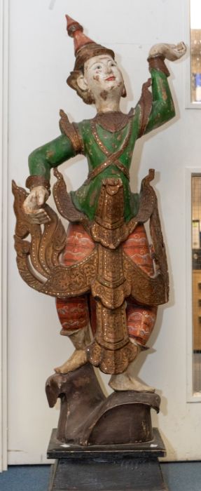 A large Burmese carved wood and painted figure of a dancing Deity, late 19th/early 20th Century,