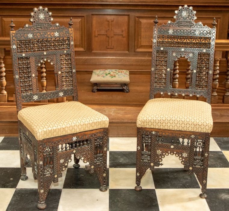 A pair of 19th century carved Middle Eastern hardwood chairs, profusely carved throughout with