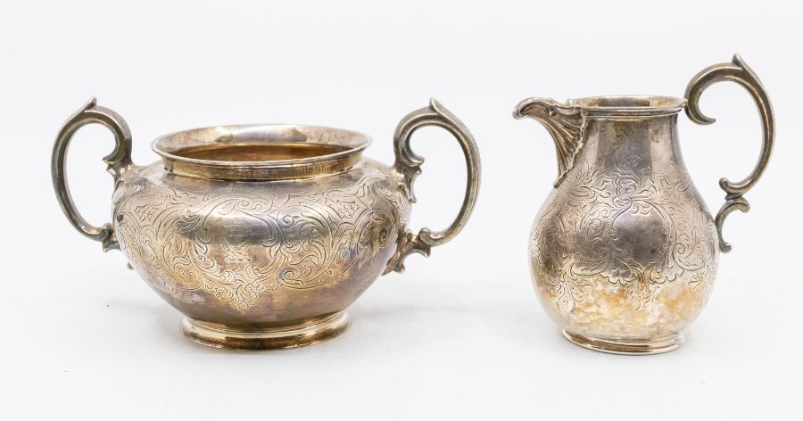 A William IV silver two handled sugar bowl and matching cream jug, profuse engraved decoration, each