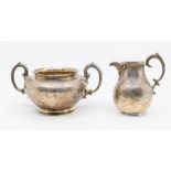 A William IV silver two handled sugar bowl and matching cream jug, profuse engraved decoration, each